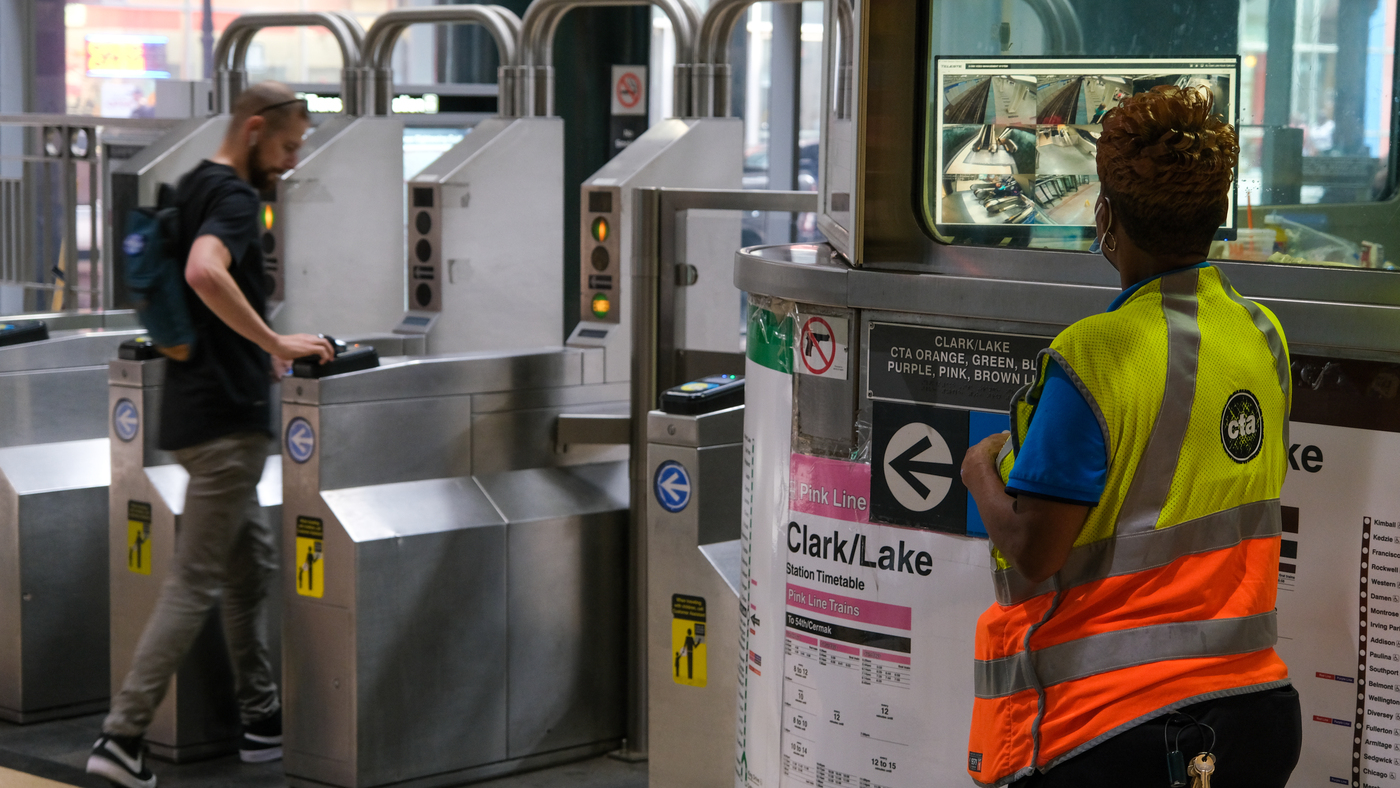A Customer Assistant at the Clark/Lake station stands outside her booth watching the security monitor while waiting to assist customers entering the facility. 