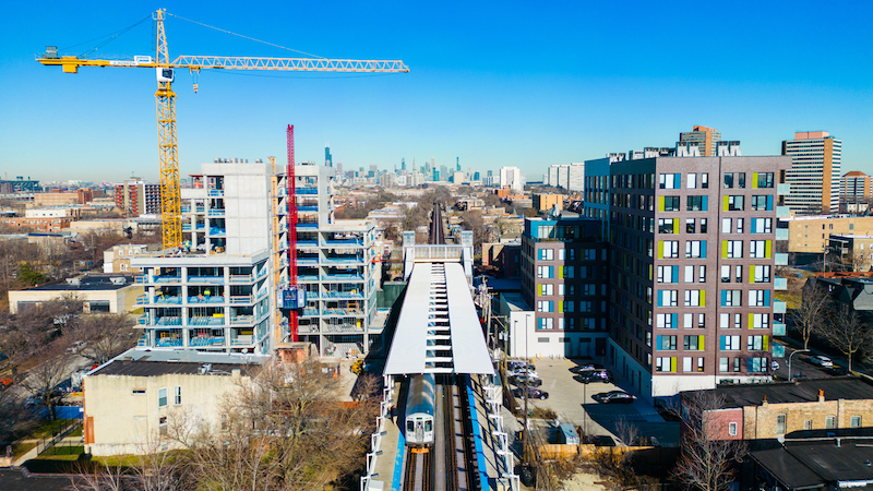 Aerial photo of construction site with crane next to Green Line train tracks