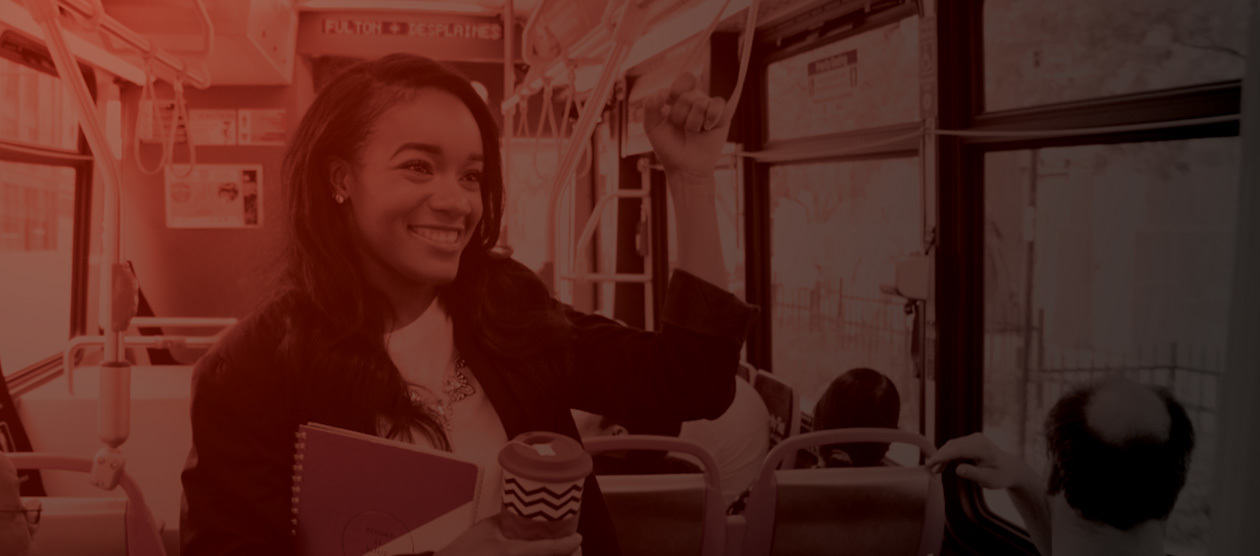 A smiling young woman riding a bus