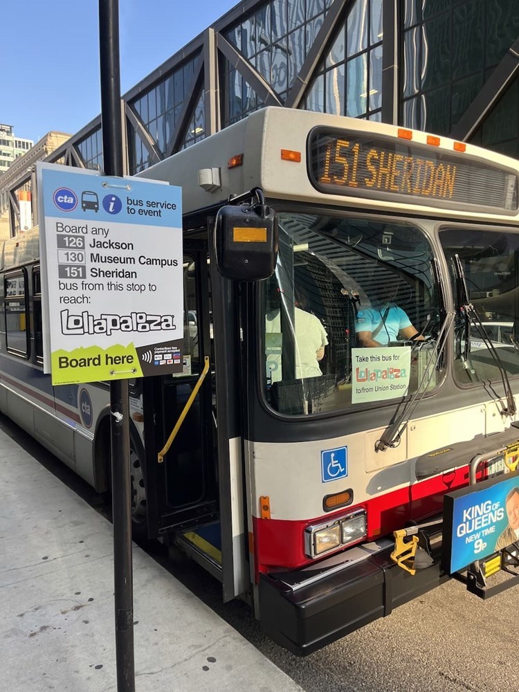 Bus sign saying, bus service to event, Lollapalooza, board here.