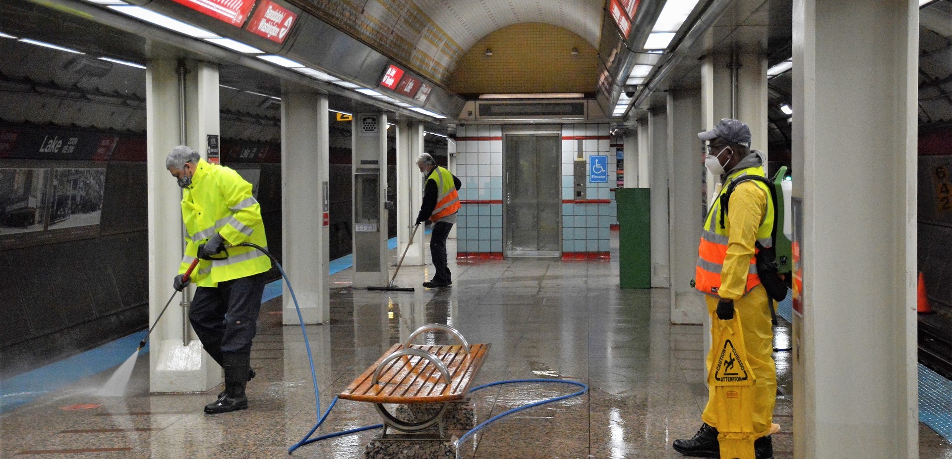 CTA personnel power washing a subway station
