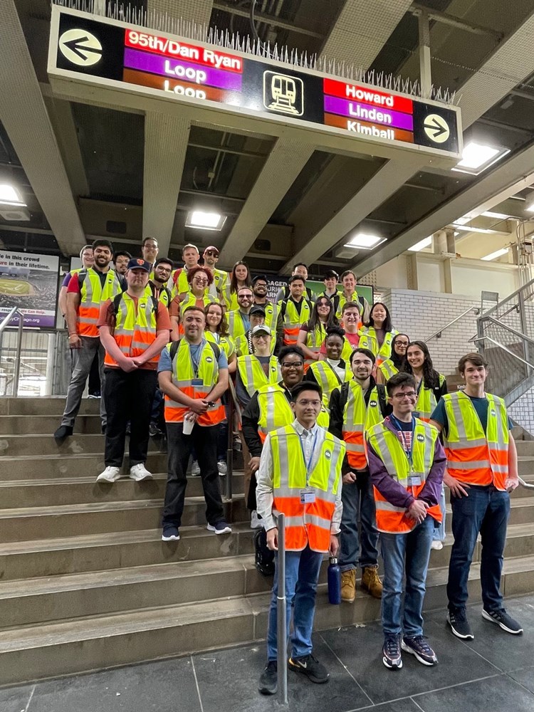 Interns posing on train station stairs