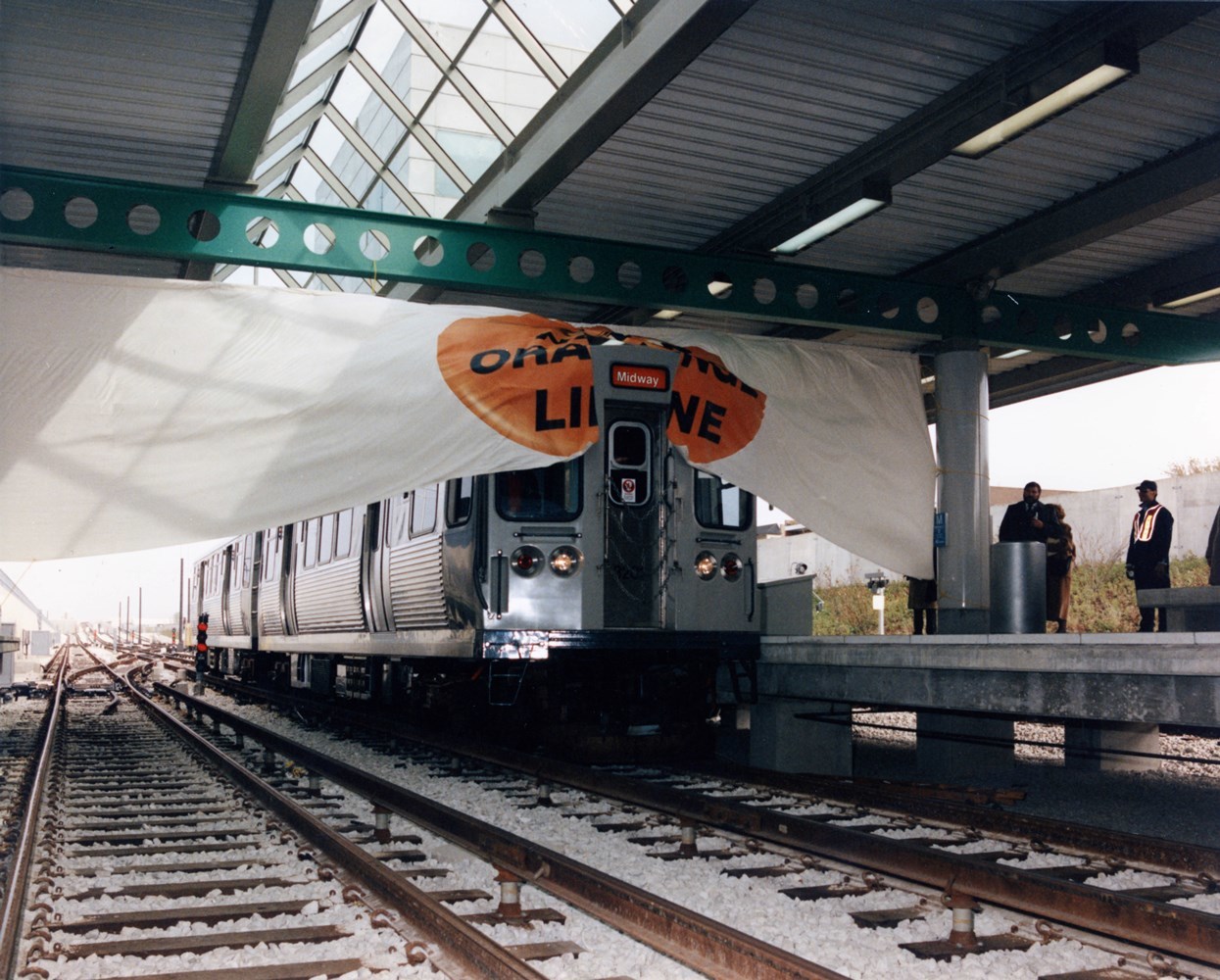 Orange Line Opening - Train breaking through banner