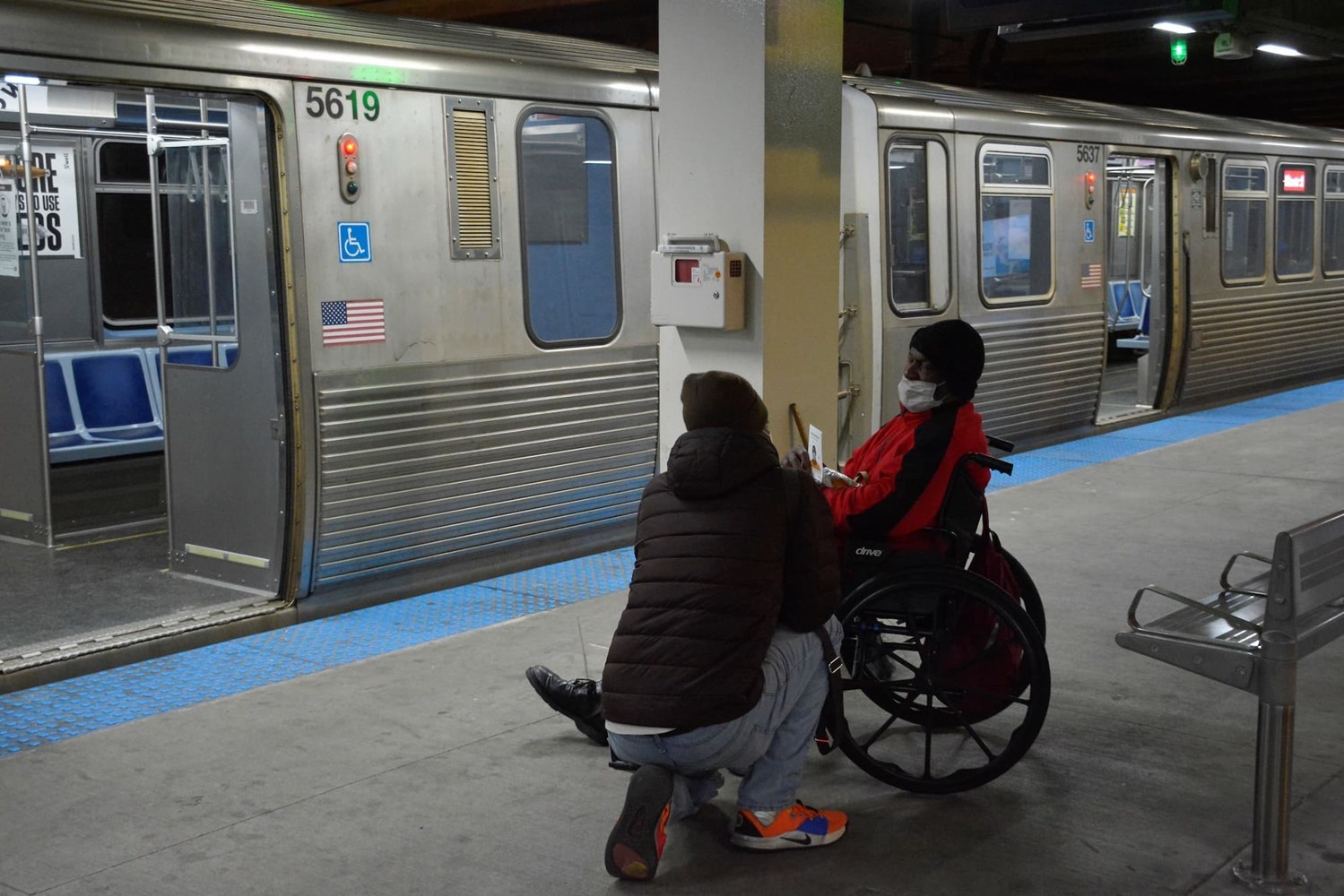 A staff member having a conversation with a man in a wheelchair