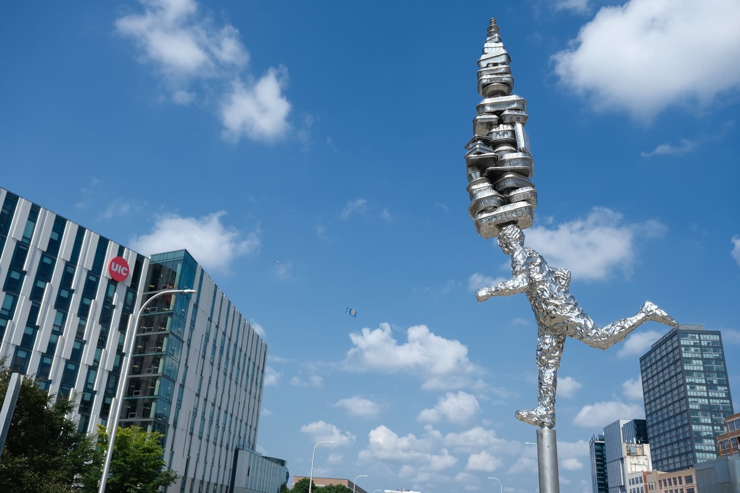 Stainless steel sculpture of the god Hermes running with takeout boxes