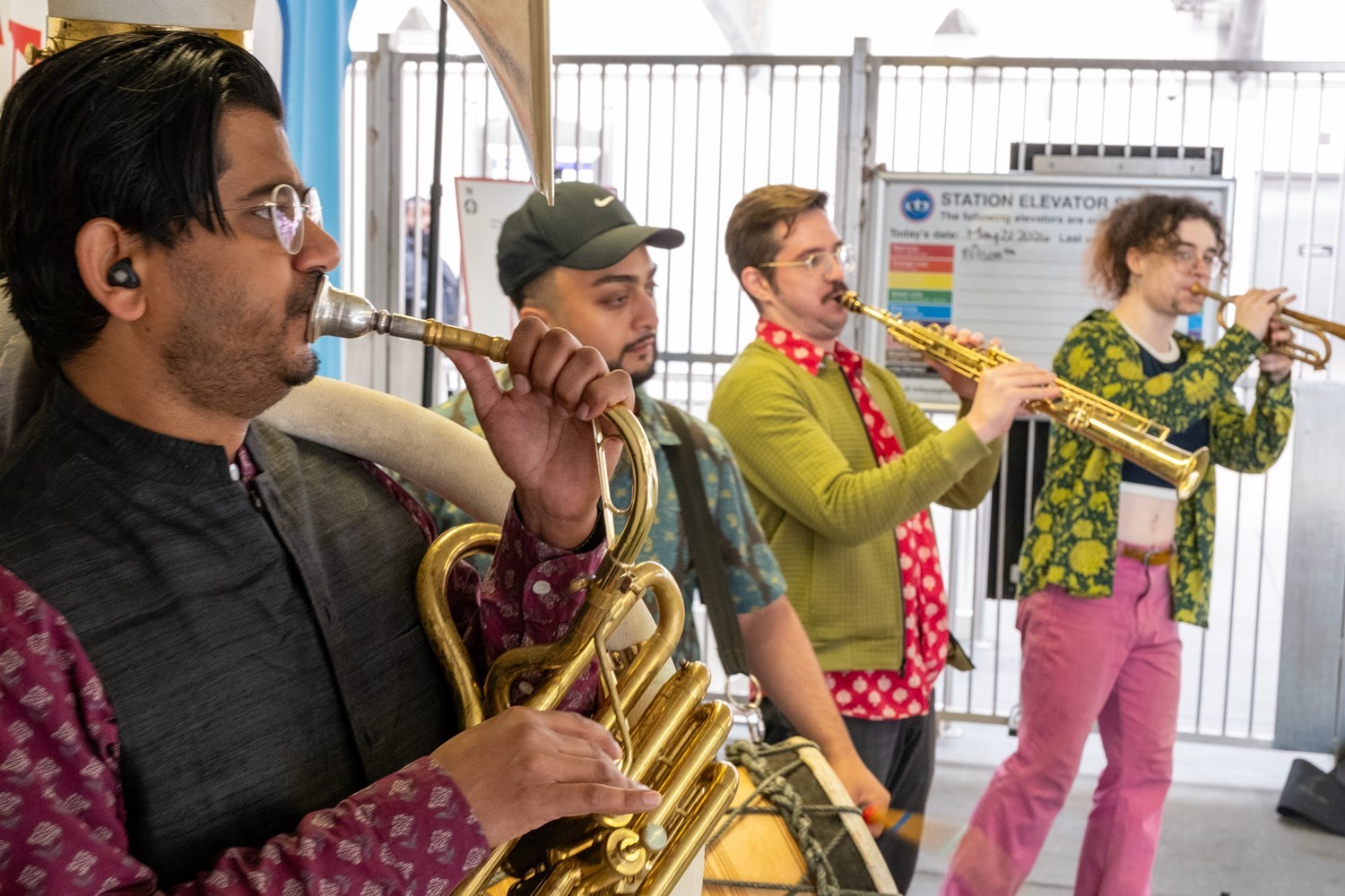 Four musicians at Howard station. Tuba, drum, alto sax, and trumpet.