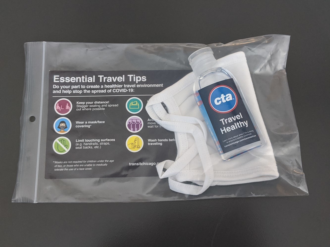 Sample CTA Travel Healthy kit featuring a reusable cloth mask, hand sanitizer and essential travel tips