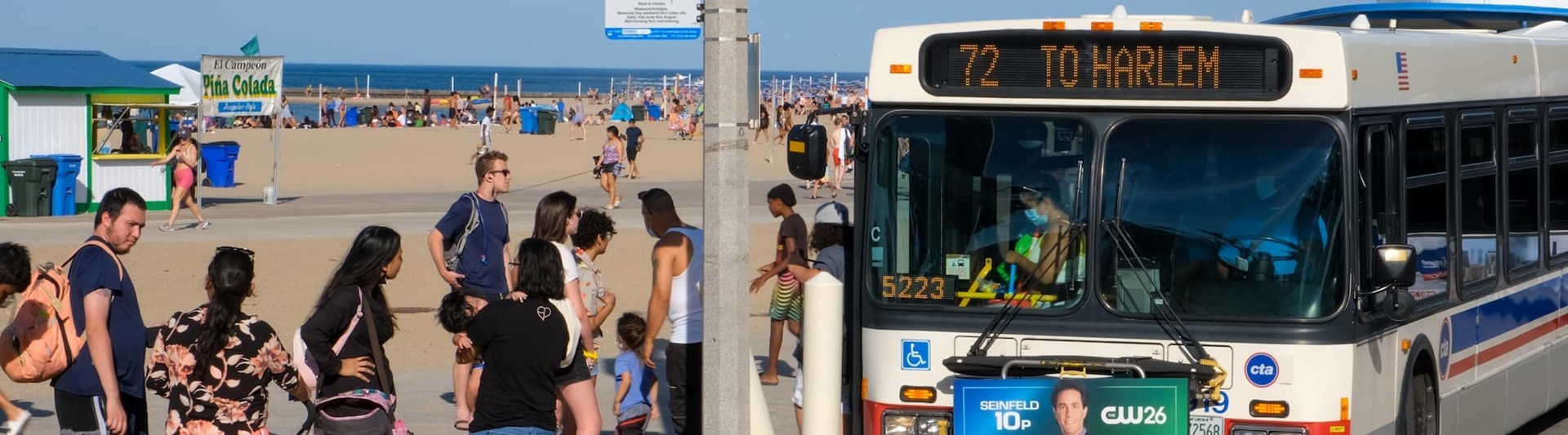 Bus parked in front of a beach on a sunny day