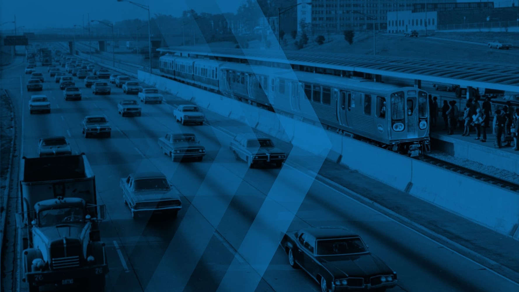 Blue tinted photo of highway and train, mixing old and new vehicles.