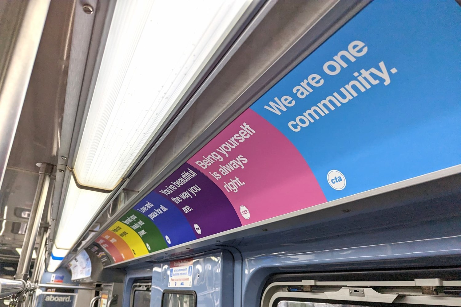 Signs inside the pride train saying "We are one community" and "Being yourself is always right"