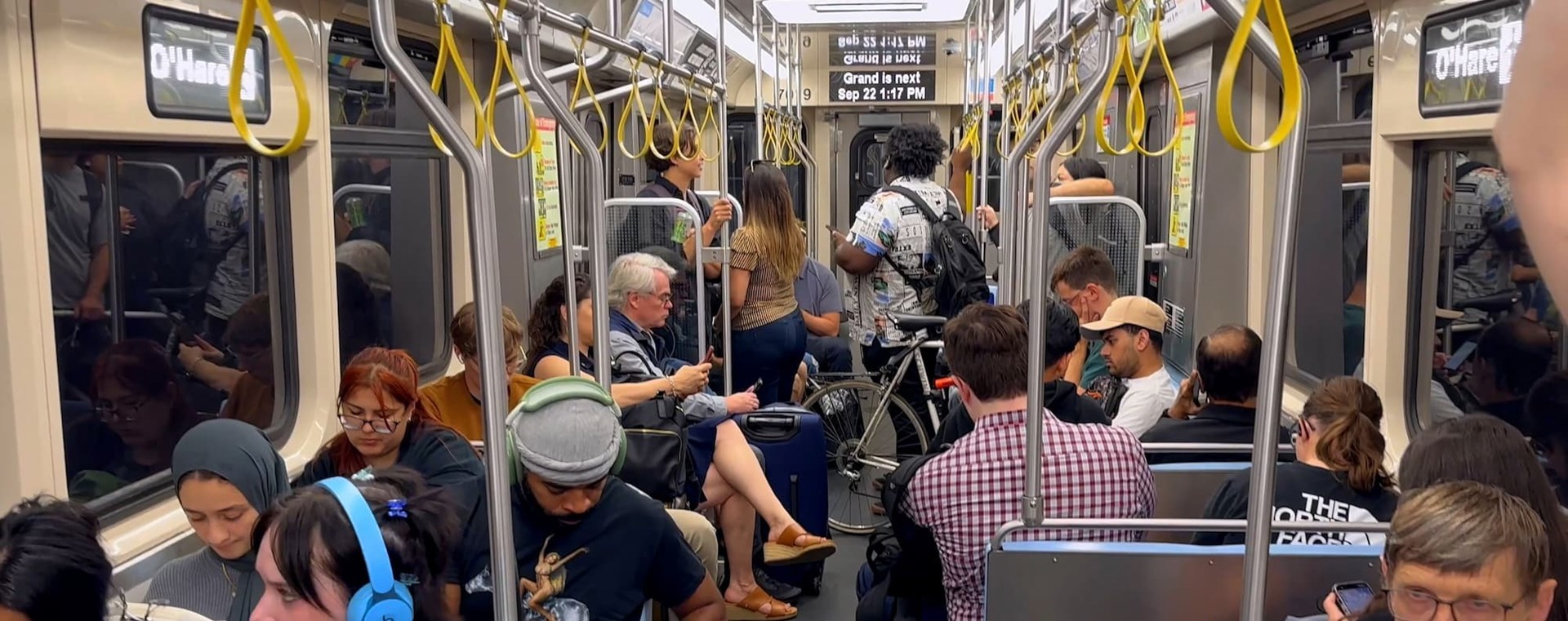 The interior of a train car with many passengers.