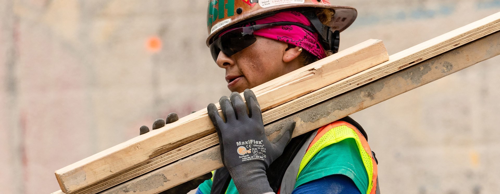 A construction worker carrying lumber.