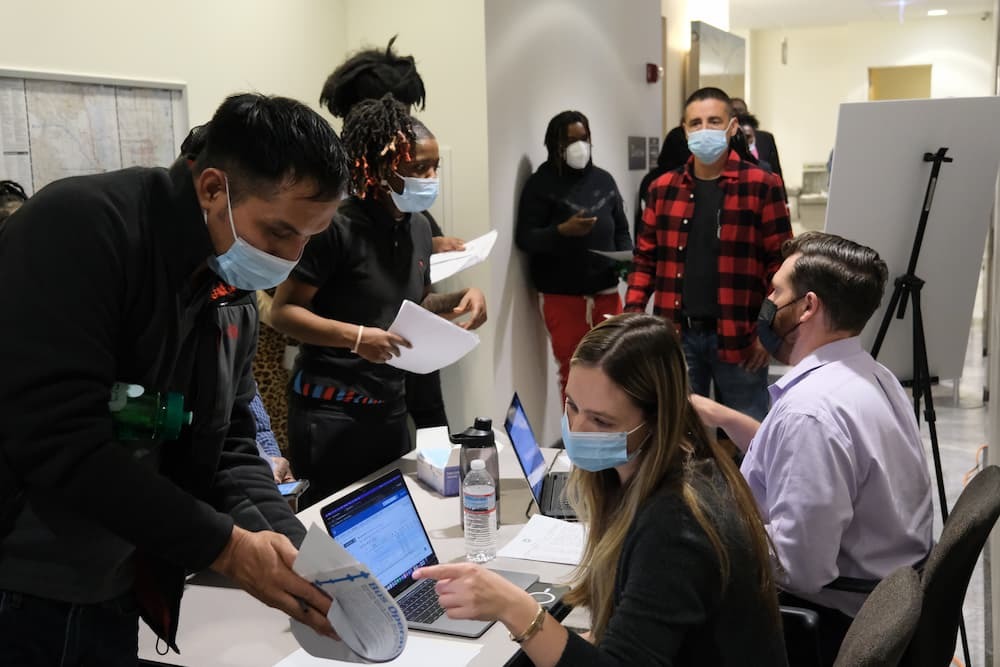 Applicants at a job fair speaking with staff