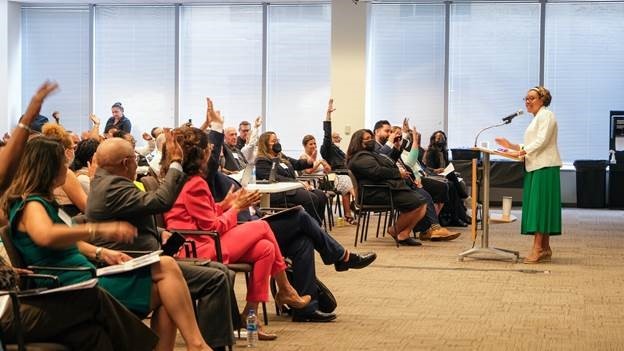 Audience with hands up to ask questions