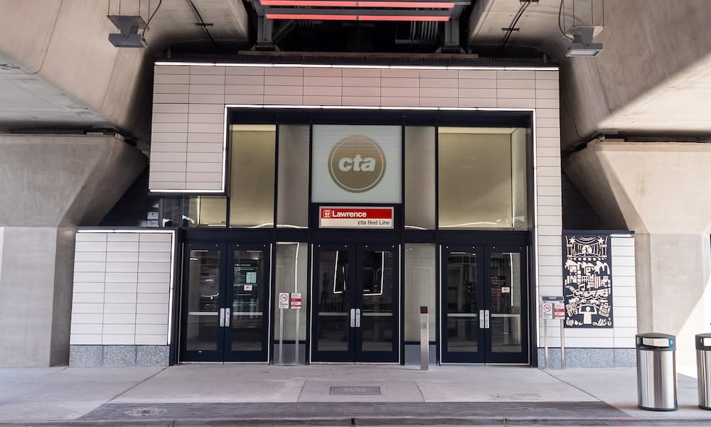 A dramatically tall entrance with three doors and artwork.