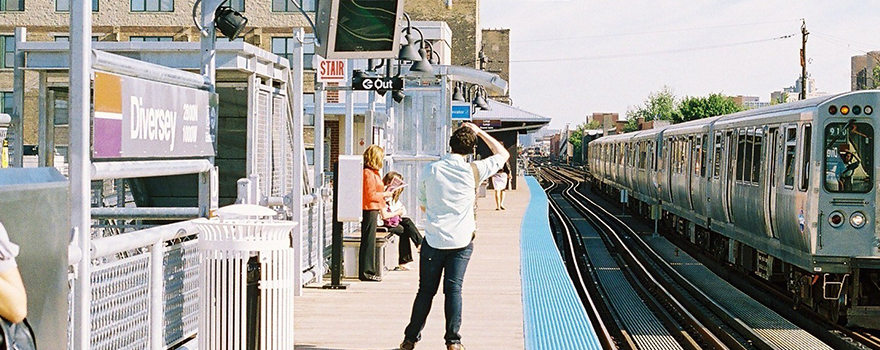 Person scratching head while looking down the tracks