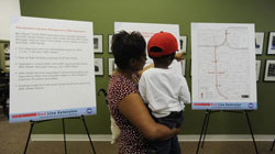 Pic of woman and child at public meeting about extension